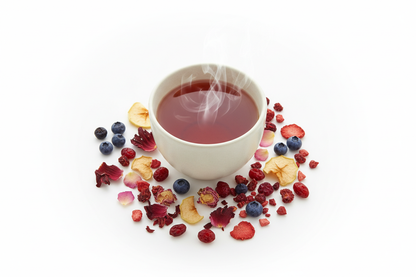 a top view of a cup of tea that has a redish hue and is steaming there are minimal scattering Elderberry, Hibiscus,  Apple,   Blueberry,   Rose petals, Cranberry, Raspberry and Strawberry pieces, about on white background